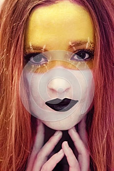 Beautiful girl with creative makeup,painting art.Yellow and white colors with black lips.Perfect,amazing,beautiful,expressive eyes