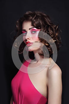 Beautiful girl with curly hair and hot pink disco makeup