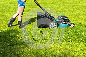 Beautiful girl cuts the lawn, Mowing lawns, Lawn mower on green grass, mower grass equipment, mowing gardener care work tool, clos
