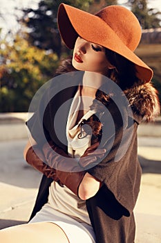 Beautiful girl with dark hair wearing elegant coat,hat and gloves