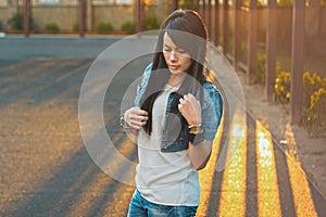 Beautiful girl in a denim jacket in the sunlight sunset.