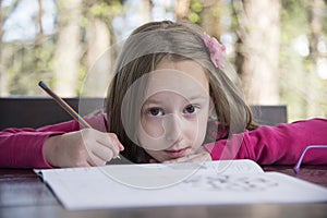 Beautiful girl doing homework at the park