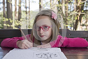 Beautiful girl doing homework at the park