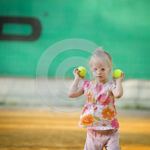 Beautiful girl with Down syndrome playing tennis