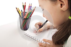 Beautiful girl is drawing with color pencils