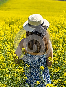 Beautiful girl with dress and hat in the Canola Fields.