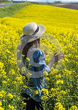 Beautiful girl with dress and hat in the Canola Fields.