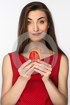 Beautiful girl in a dress with perfect smile eating red strawberry. Healthy food. Isolated on white.