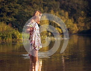 Beautiful girl in dress on the river