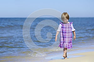 Beautiful girl in a dress walking on the beach