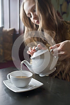 Beautiful Girl Drinking Tea or Coffee in Cafe