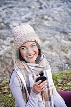 beautiful girl drinking tea near the river