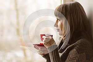 Beautiful girl drinking Tea near Window