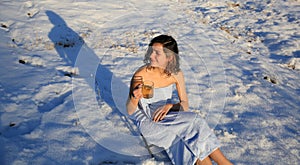 Beautiful girl drinking tea on the snow in winter.