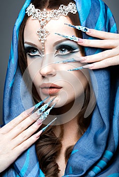 Beautiful girl in eastern Arabic image with long nails and bright blue make-up.