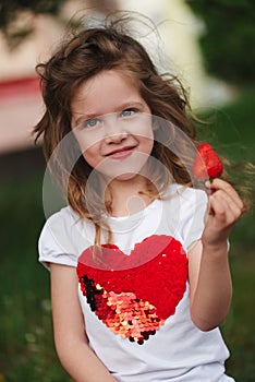 Beautiful girl eating big juicy strawberry