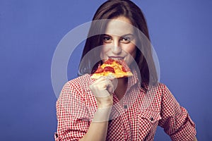 Beautiful girl eating a slide of pizza