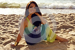 Beautiful girl in elegant dress relaxing on summer beach