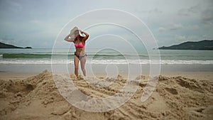 Beautiful girl enjoying summer beach holidays comes into the sea. Travel vacation of happy woman in bikini