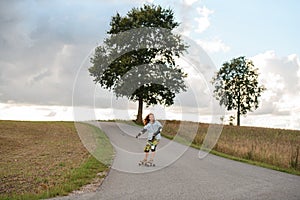 beautiful girl enjoys a funny longboard ride on country road.