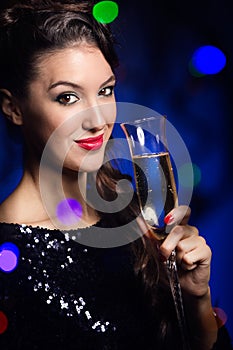 Beautiful girl in evening dress with wine glass. New Year's Eve.