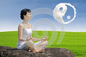 Beautiful girl exercise yoga with ying yang cloud