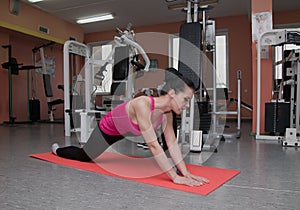Beautiful girl is exercising in the fitness club on the rug. Stretching