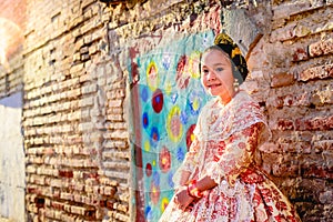 Beautiful girl fallera wearing the traditional Valencian costume of Fallas, during a beauty session and posing outdoors photo