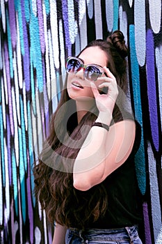 A beautiful girl in a fashion situation posing with a sunglasses