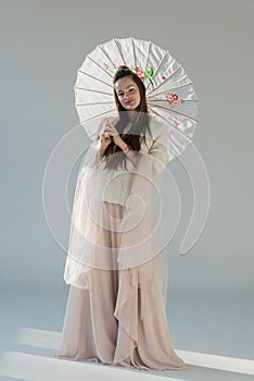 beautiful girl in fashionable winter outfit standing with japanese umbrella