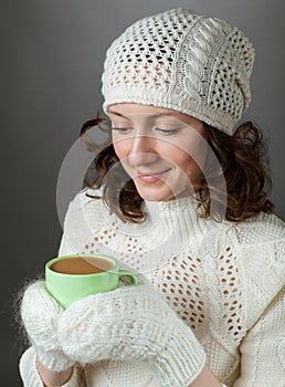 Beautiful girl feeling cold and holding a cup of hot drink