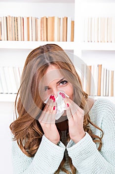 Beautiful girl feeling ill caught cold sniffles blowing her nose