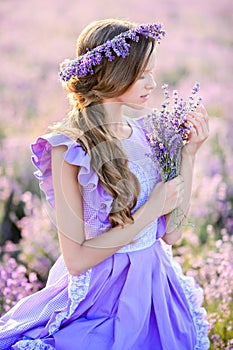 Beautiful girl in a field of lavender on sunset.
