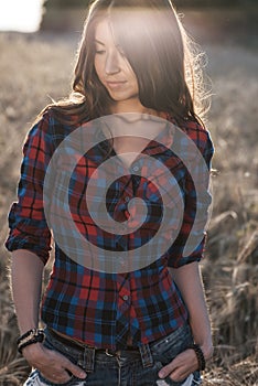 Beautiful girl field. Summer in nature. Happy smiling looking in frame. In the evening shirt a brunette woman, a close