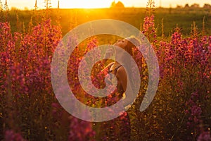 Beautiful girl on field, sun backlight, sunrise