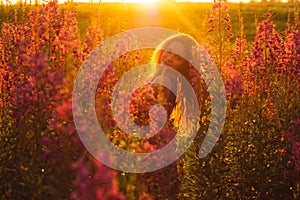 Beautiful girl on field, sun backlight, sunrise