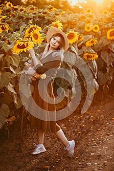 beautiful girl in a field of sunflowers at sunset
