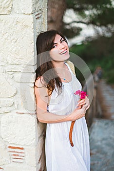 A beautiful girl with a flower in a wihite dress