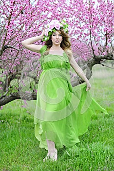 Beautiful girl in a flowered garden peach