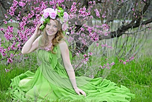 Beautiful girl in the flowered garden peach