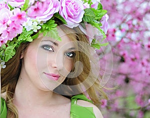 Beautiful girl in the flowered garden peach