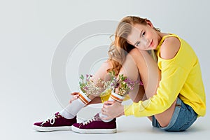 beautiful girl with flowers in socks sitting and looking at camera