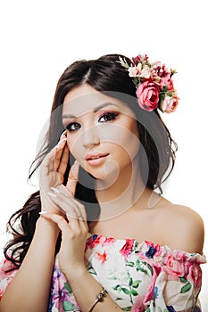 Beautiful girl with flowers. Spring woman. Lady with bright makeup and a flowering branch in her hair. Spring time