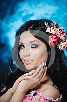 Beautiful girl with flowers. Spring woman. Lady with bright makeup and a flowering branch in her hair. Spring time. On dark