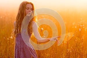 Beautiful girl in fog touching spiderweb