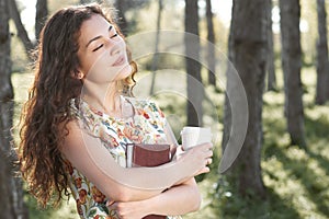 Beautiful girl in the forest, bright sunlight around, green grass and trees