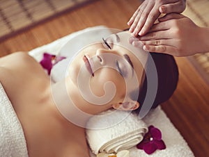 Beautiful girl getting face lifting massage in spa salon. Health care, rejuvenation and relaxation concept.