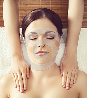 Beautiful girl getting face lifting massage in spa salon. Health care, rejuvenation and relaxation concept.