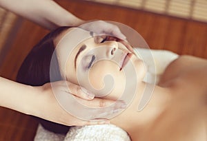 Beautiful girl getting face lifting massage in spa salon. Health care, rejuvenation and relaxation concept.