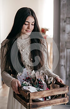 Beautiful girl with gifts in wooden christmas decor